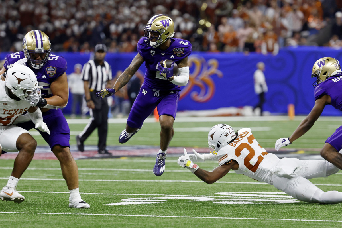 Jan 1, 2024; New Orleans, LA, USA; Washington Huskies wide receiver Ja'Lynn Polk (2) leaps over Texas Longhorns defensive back Jahdae Barron (23) during the third quarter of the 2024 Sugar Bowl college football playoff semifinal game at Caesars Superdome.